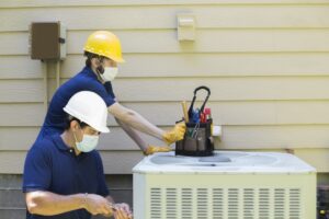 two-HVAC-technicians-inspecting-AC-cabinet